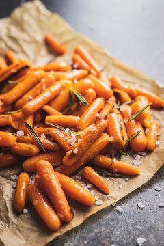 Roasted baby carrots with salt and rosemary on baking paper.