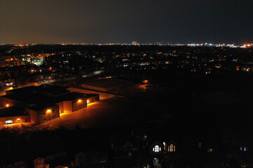 Aerial shot of a school park and the surrounding suburbs and City at night