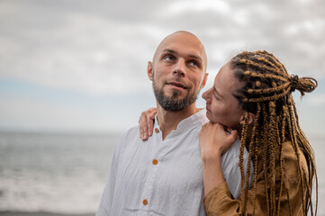 Obraz premium Young loving couple standing and hugging on a beach