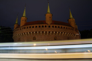 Kraków Barbican by night. Historic fortified gateway of the Old Town of Krakow, Poland. With bus...