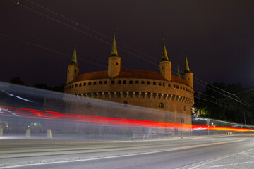 Kraków Barbican by night. Historic fortified gateway of the Old Town of Krakow, Poland. With bus...