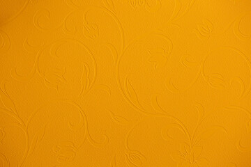 Yellow wall with abstract spots as a background. Beautiful golden texture with patterns, decorative plaster. Modern bright wall painting in trendy shades, unusual spotted yellow and gold surface.