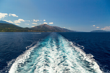 Bright sea water trail behind a cruise ship summer time. Ferry boat leaves a trail in a blue and...