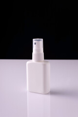 white aerosol bottles on white table and black background