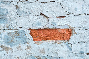 Ancient weathered brick wall with cracks and destroyed stucco layer. old brick wall. Vintage background texture. Cracked concrete vintage wall background, old brick wall