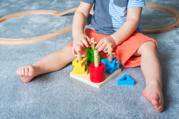 Toddler boy plays in playroom with educational toys...