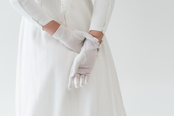 back view of bride in gloves and white dress isolated on grey.