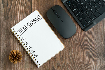 2023 goals text on note pad on top of wood desk