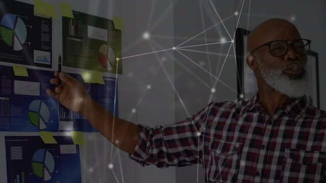 Animation of network of connections over senior african american man making presentation