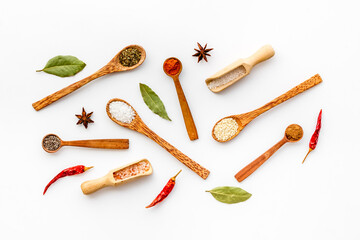 Cooking background with colorful spices and herbs in wooden spoons, top view