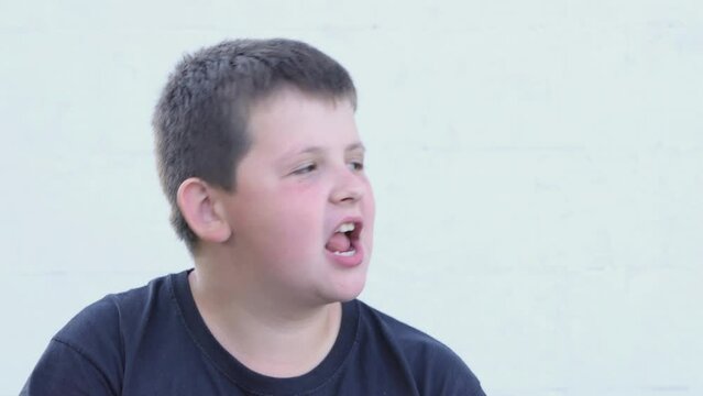 Overweight boy eats potato chips, close-up on the street. Unhealthy food