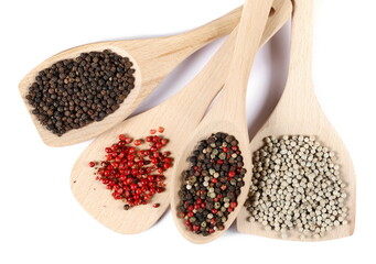 Set black, red, colorful and white grains pepper pile in wooden spoon isolated on white, top view
