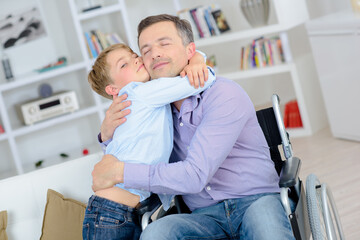 dad in a wheelchair hugs his son