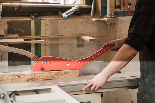 Closeup of unrecognizable male carpenter hands use metal planning machine with cutting blade tool, knife saw. Woodwork