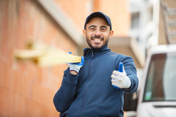 portrait of handyman carrying wood while gesturing thumbs up
