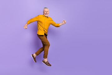 Fototapeta na wymiar Full length profile side photo of mature man runner jumper movement isolated over purple color background