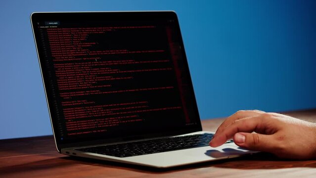 Programmer using laptop. Program code and script data on the screen close-up. Hacker attack. 