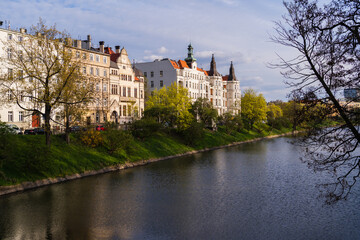 Fototapeta na wymiar Buildings and trees on embankment near river in Wroclaw