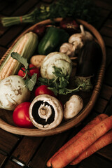 Grocery basket, rustic basket with vegetables: corn, mushrooms, turnips, dill, tomatoes, buryak, pepper, garlic. Assortment of seasonal vegetables for a healthy diet
