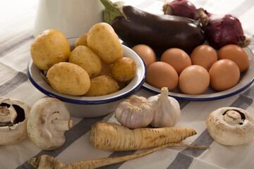 A set of essential products: milk, eggs, eggplant, garlic, potatoes, turnips and other vegetables....