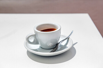popołudniowe espresso na oświetlonym słońcem stoliku - obrazy, fototapety, plakaty