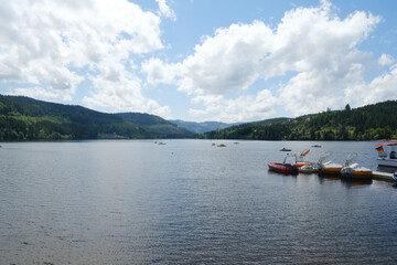 Fototapeta na wymiar A panoramic view of Titisee Lake at Black Forest region with several boat insight. Part of tourist attraction in German