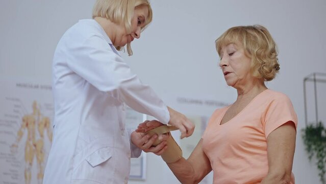 Traumatologist removing cast from patient's arm, healed hand, recovery process