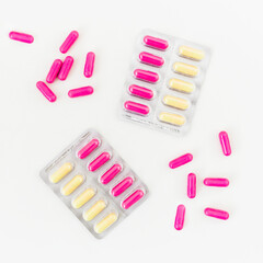 Pills with vitamins on white background. Flat lay