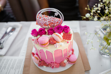 beautiful pink birthday cake with cookies on the table