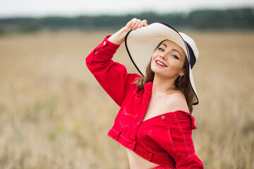 beautiful young woman in hat in summer field	