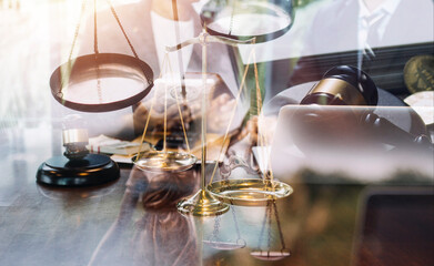 Justice and law concept.Male judge in a courtroom with the gavel, working with, computer and docking keyboard, eyeglasses, on table in morning light
