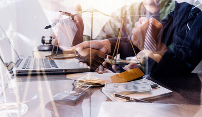 Justice and law concept.Male judge in a courtroom with the gavel, working with, computer and docking keyboard, eyeglasses, on table in morning light