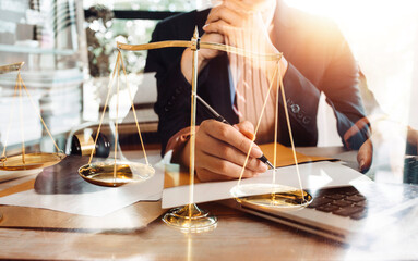 Justice and law concept.Male judge in a courtroom with the gavel, working with, computer and docking keyboard, eyeglasses, on table in morning light