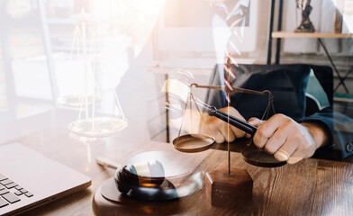 Fototapeta na wymiar Justice and law concept.Male judge in a courtroom with the gavel, working with, computer and docking keyboard, eyeglasses, on table in morning light