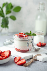jar of yogurt with strawberries and milk on the table