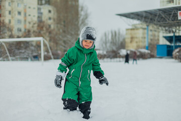 Fototapeta na wymiar a boy outside in the snow. winter walks. a child is playing outside in the snow. Winter Games.