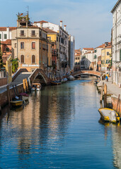 canal with boats docked and charming architecture in Venice, Italy 