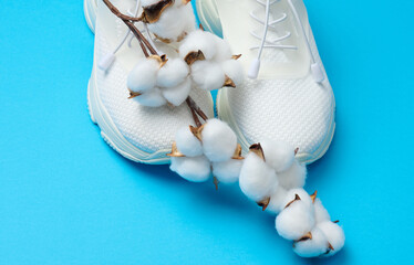 White textile sneakers on a blue background, top view
