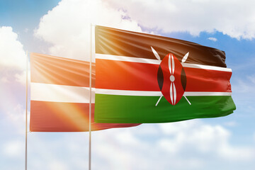 Sunny blue sky and flags of kenya and latvia
