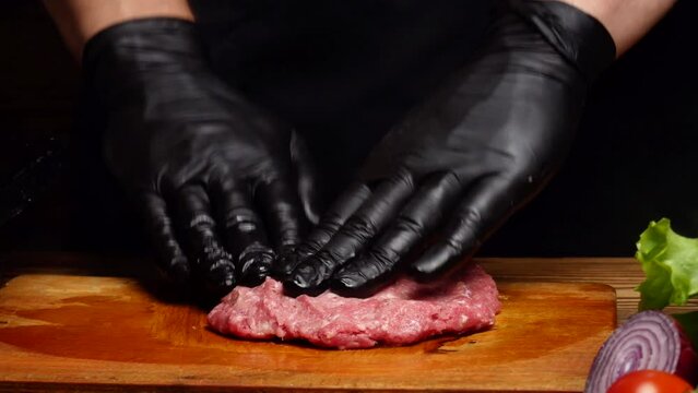 Chef mixing ground beef and shaping a burger patty