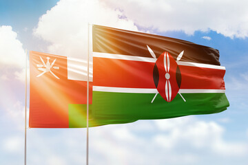 Sunny blue sky and flags of kenya and oman