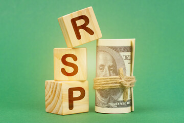On a green surface, dollars and cubes with the inscription - RSP