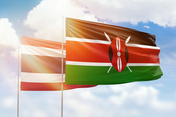 Sunny blue sky and flags of kenya and thailand