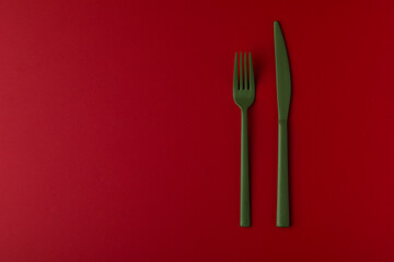 Green cutlery on the red background.