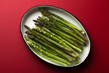 A bunch of asparagus on a red background.