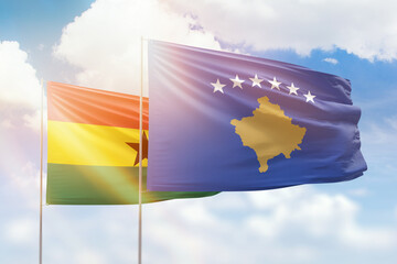 Sunny blue sky and flags of kosovo and ghana