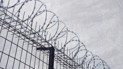 Concertina barb wire, heavy duty, metal fence. A prison, crime concept low angle shot