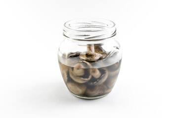 Isolated glass jar with marinated champignon mushrooms on a white background, open snack, home canning