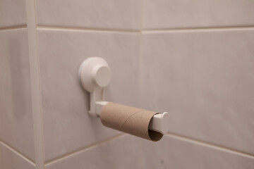 Empty toilet roll on toilet paper holder. WC, restroom, lavatory and bathroom detail. Very shallow focus and depth of field.