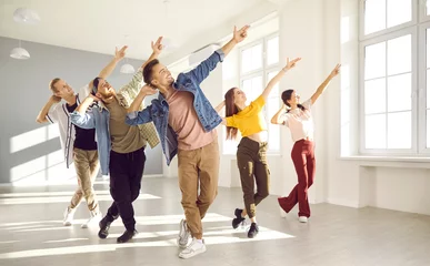 Gordijnen Gelukkige energieke jonge hiphopdansers dansen samen in een lichte, ruime dansstudio. Actieve jonge vrouwen en mannen in moderne vrijetijdskleding jagen hun hobby& 39 s na en leren samen nieuwe dansbewegingen. © Studio Romantic